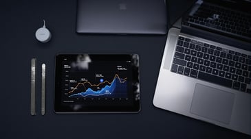 Laptop and tablet showcasing data visualization charts on a dark workspace, highlighting productivity tools and tech.